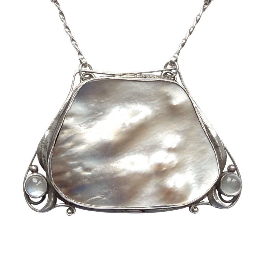 An Arts and Crafts silver pendant featuring a central trapezoidal blister pearl flanked by two round cabochon moonstones, attached to a twisted silver link chain. View II