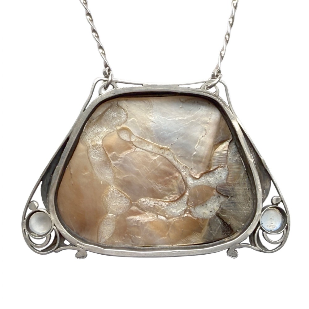 An Arts and Crafts silver pendant featuring a central trapezoidal blister pearl flanked by two round cabochon moonstones, attached to a twisted silver link chain. View VI