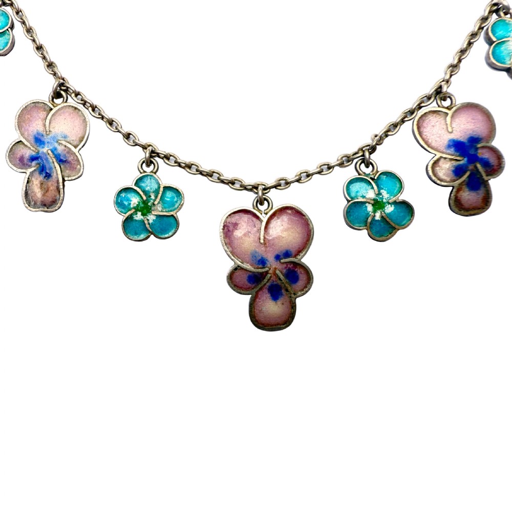 An antique silver necklace featuring dangling enamel pansy flower charms suspended from a delicate chain. View II