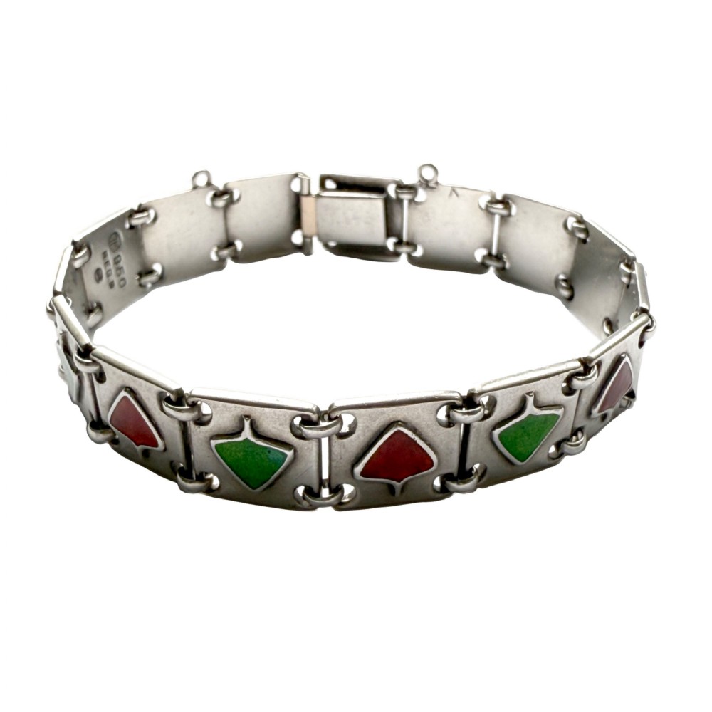 A German Jugendstil silver panel bracelet featuring linked rectangular segments inset with red and green enamelled geometric motifs.