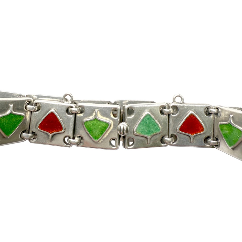 A German Jugendstil silver panel bracelet featuring linked rectangular segments inset with red and green enamelled geometric motifs. View IV