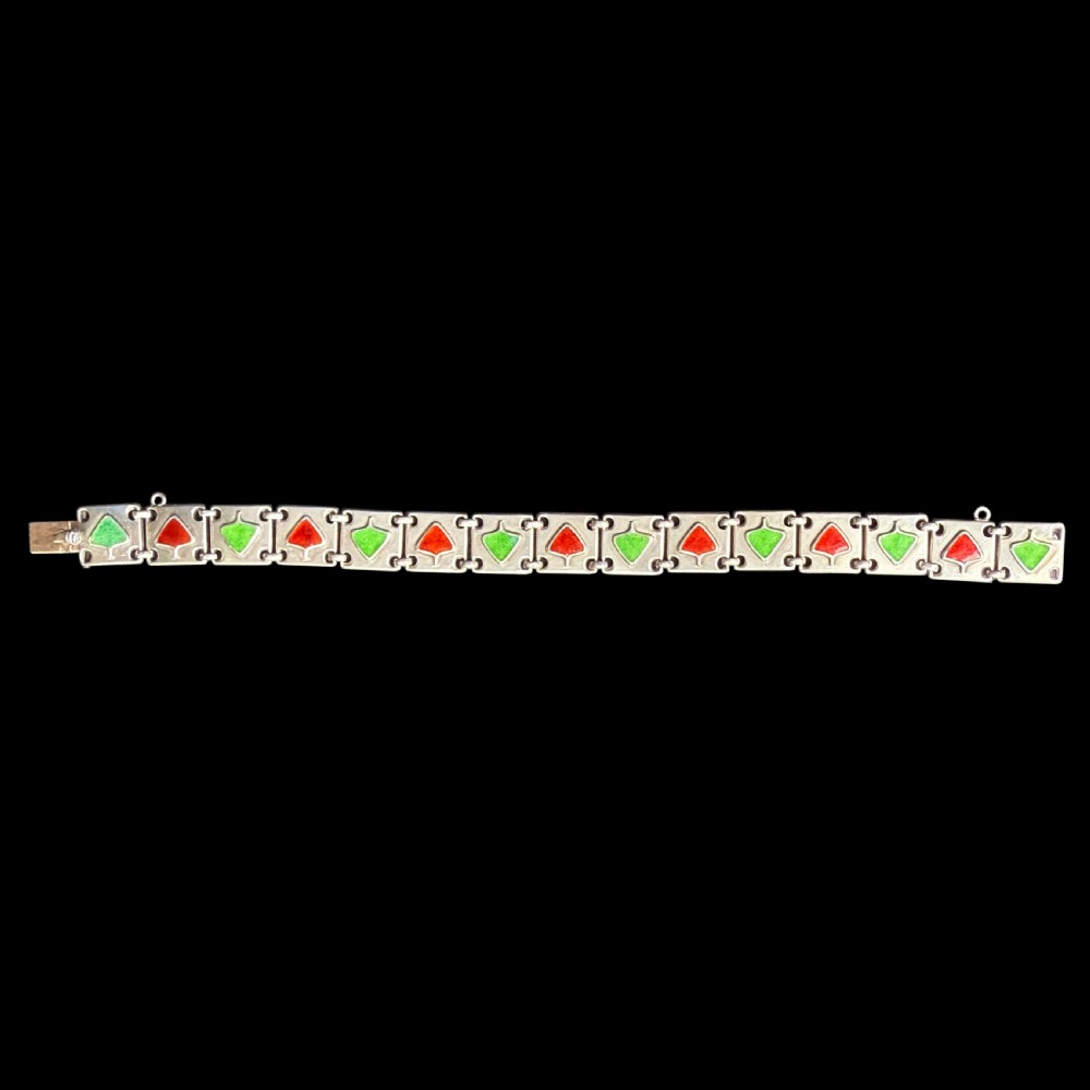 A German Jugendstil silver panel bracelet featuring linked rectangular segments inset with red and green enamelled geometric motifs. View VI