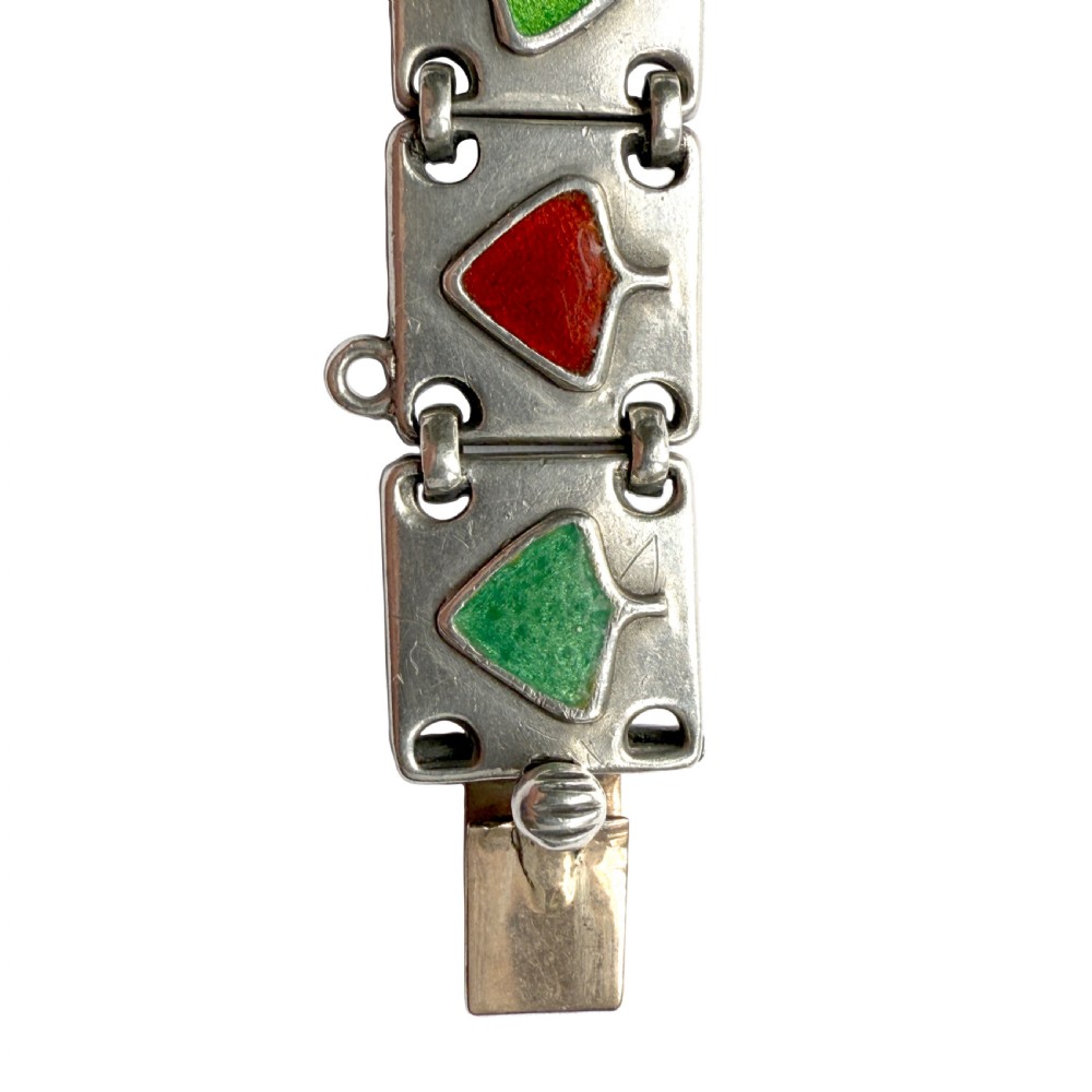 A German Jugendstil silver panel bracelet featuring linked rectangular segments inset with red and green enamelled geometric motifs. View VII