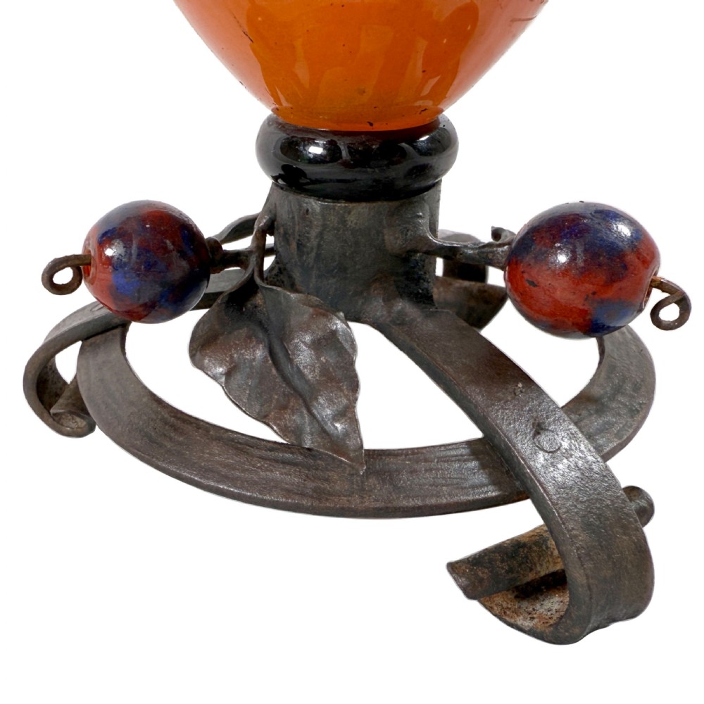 An Art Deco mottled orange and brown blown glass vase mounted on a wrought iron tripod base with forged leaf and berry accents. View VII