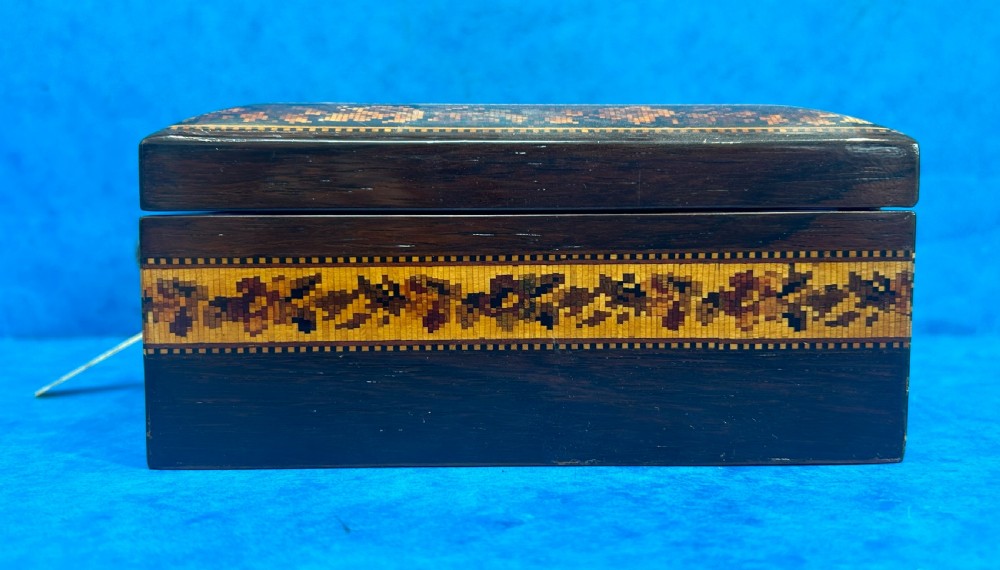 A square Victorian wooden box featuring a central floral mosaic inlay panel, detailed geometric mosaic borders, and a metal key. View VIII