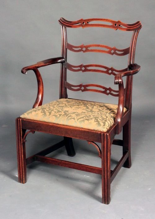 A dark mahogany Chippendale ladder back armchair featuring pierced serpentine horizontal slats, swept arms, a patterned upholstery drop-in seat, and square legs with corner brackets.
