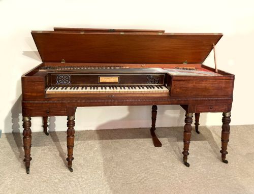 fig 1. A Regency mahogany square piano crafted by Wood, Small and Co, raised on turned reeded legs with brass castors and featuring an open music rest.
