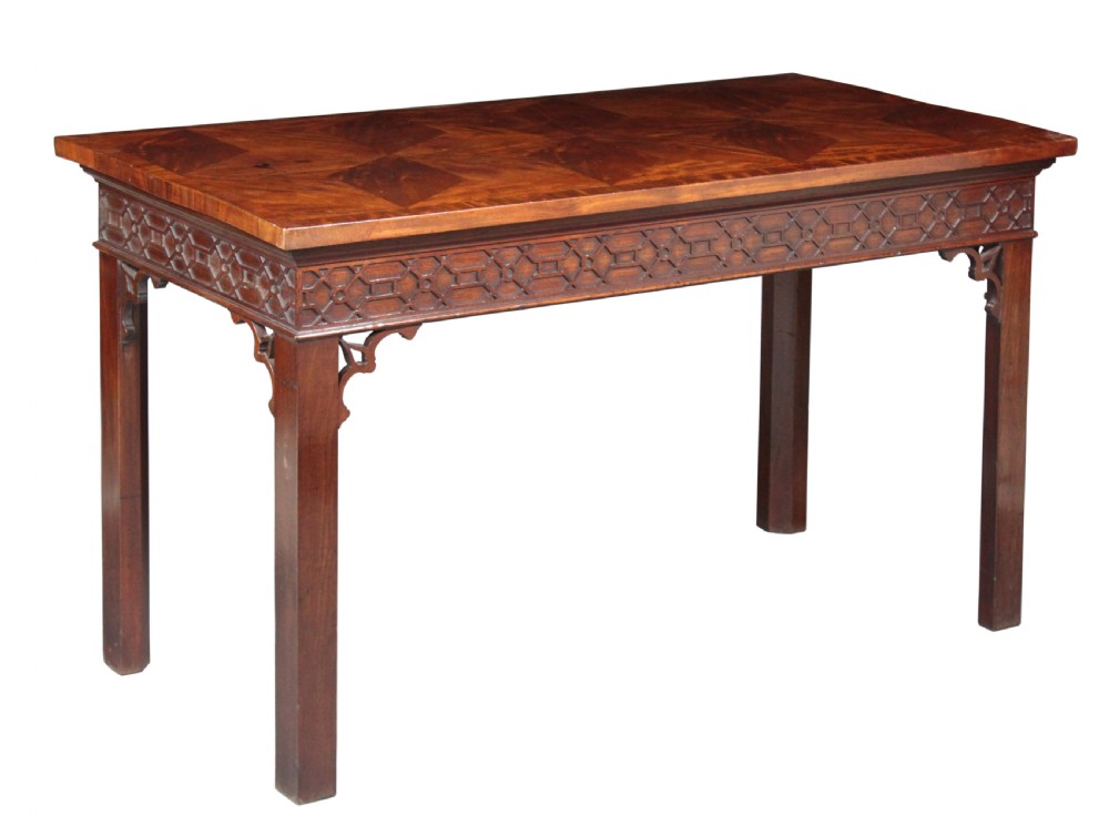 A dark mahogany rectangular Chippendale side table with a parquetry top, blind fretwork carved frieze, pierced corner brackets, and straight square legs.