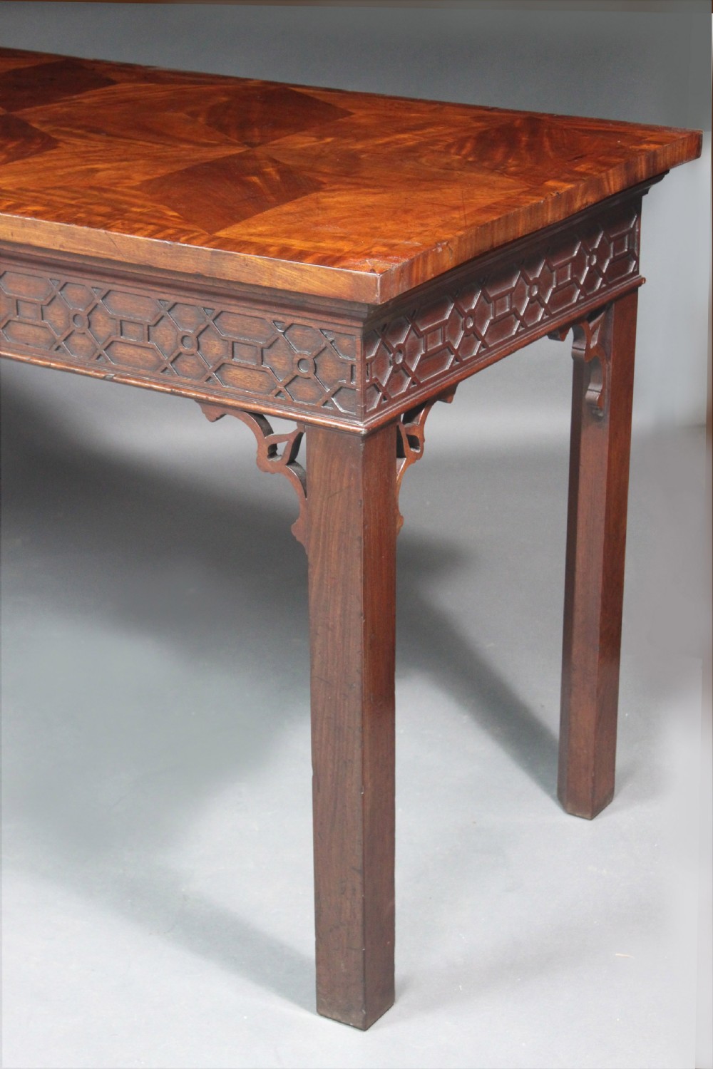 A dark mahogany rectangular Chippendale side table with a parquetry top, blind fretwork carved frieze, pierced corner brackets, and straight square legs. View III