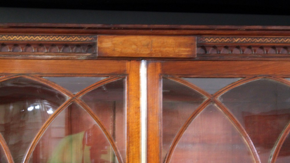 A large George III mahogany breakfront bookcase with glazed upper doors featuring Gothic astragal glazing bars and panelled lower cupboard doors. View IV