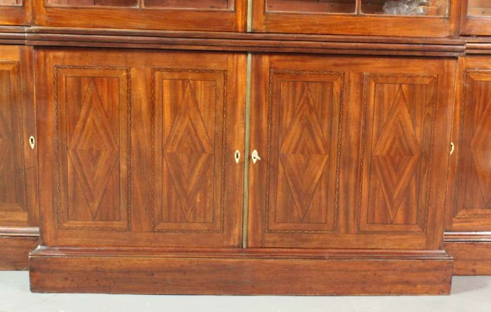 A large George III mahogany breakfront bookcase with glazed upper doors featuring Gothic astragal glazing bars and panelled lower cupboard doors. View V
