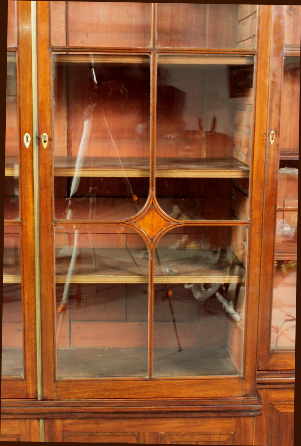A large George III mahogany breakfront bookcase with glazed upper doors featuring Gothic astragal glazing bars and panelled lower cupboard doors. View VIII