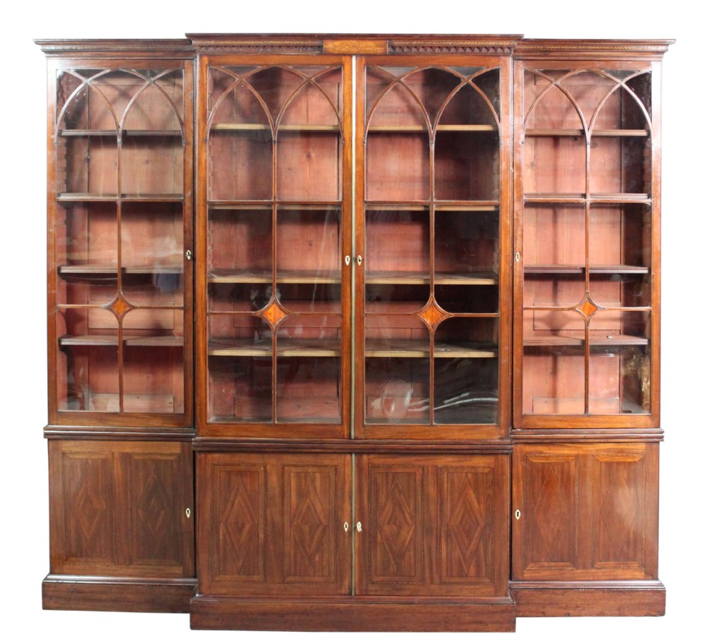 A large George III mahogany breakfront bookcase with glazed upper doors featuring Gothic astragal glazing bars and panelled lower cupboard doors. View II