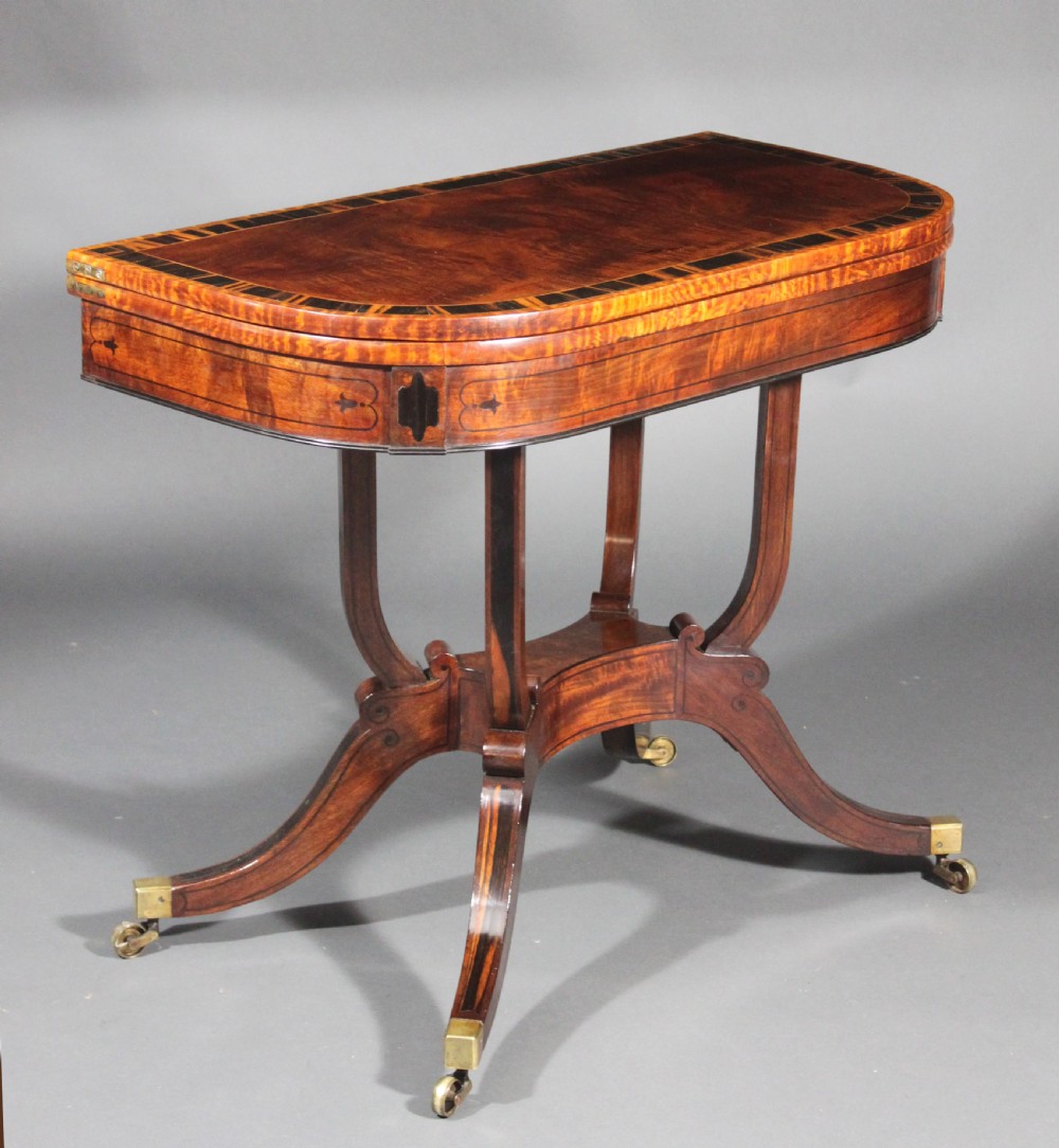 A matching three-piece Regency period furniture set featuring a central sofa table with drawers flanked by a pair of D-shaped folding card tables, all crafted with figured wood and crossbanded inlay borders on curved legs with brass castors. View XIV