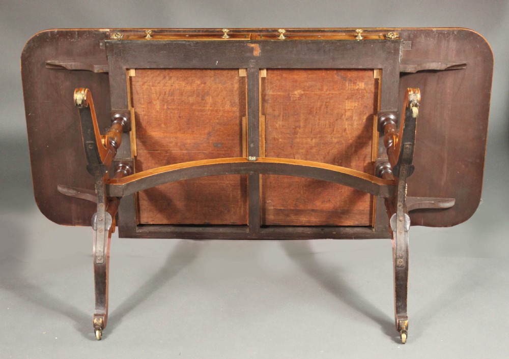 A Regency period kingwood sofa table with brass inlay, two drawers, drop-leaf sides, turned legs, an arched stretcher, and brass castors. View VIII