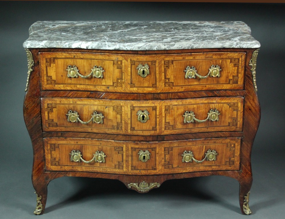 A Louis XV style kingwood commode featuring three drawers with geometric parquetry inlay, gilt bronze mounts, and a shaped grey marble top. View IV