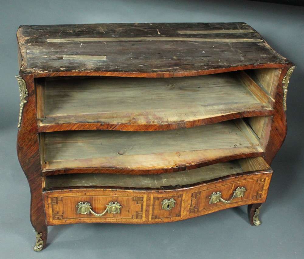 A Louis XV style kingwood commode featuring three drawers with geometric parquetry inlay, gilt bronze mounts, and a shaped grey marble top. View X