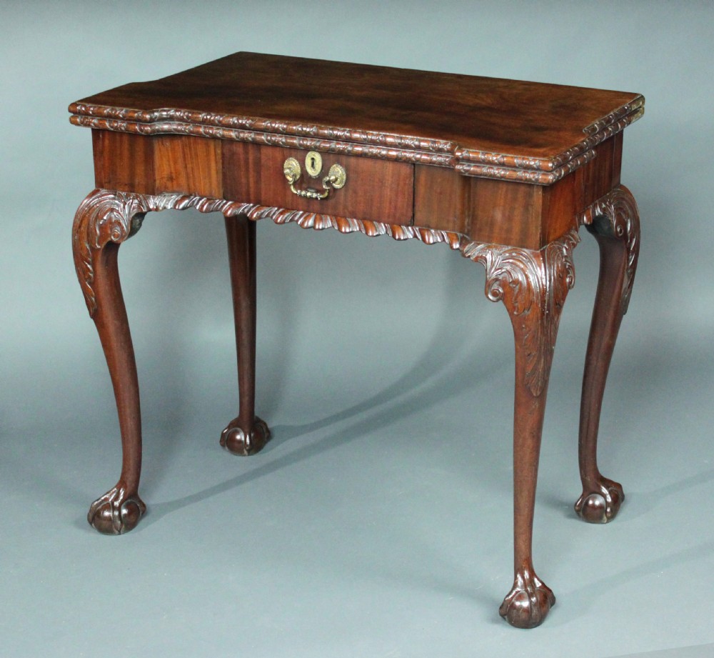An antique Chippendale mahogany fold-over card table with cabriole legs, carved ball and claw feet, and a single drawer with brass hardware. View II