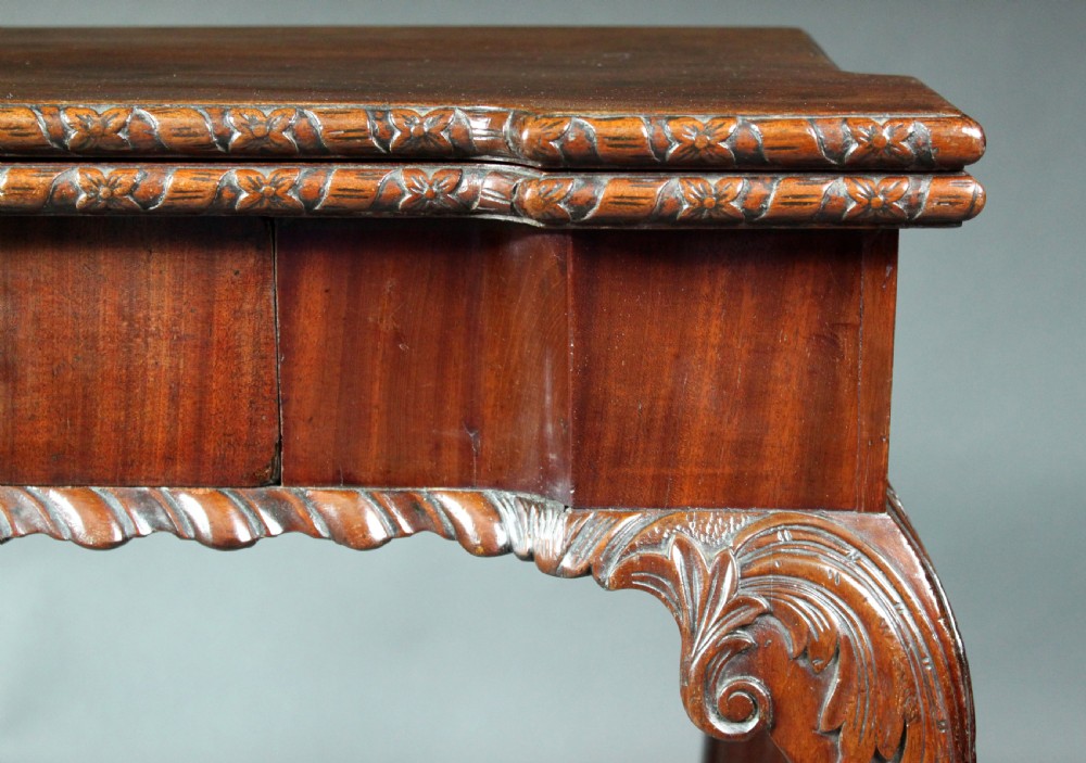 An antique Chippendale mahogany fold-over card table with cabriole legs, carved ball and claw feet, and a single drawer with brass hardware. View IV
