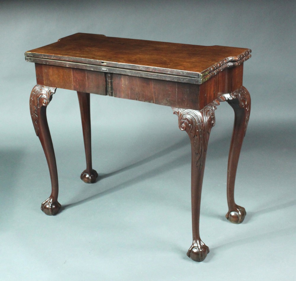 An antique Chippendale mahogany fold-over card table with cabriole legs, carved ball and claw feet, and a single drawer with brass hardware. View VII