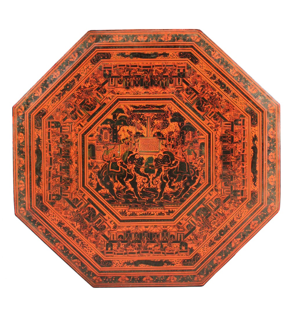 An octagonal red lacquer side table decorated with black hand-painted figures, elephants, and geometric borders. View III