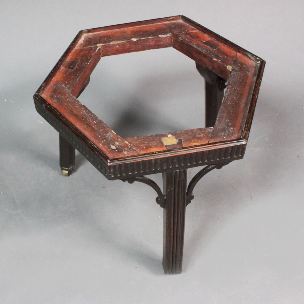 A hexagonal mahogany wine cooler featuring polished brass bands, side handles, and a fitted stand with fluted legs and brass castors. View V