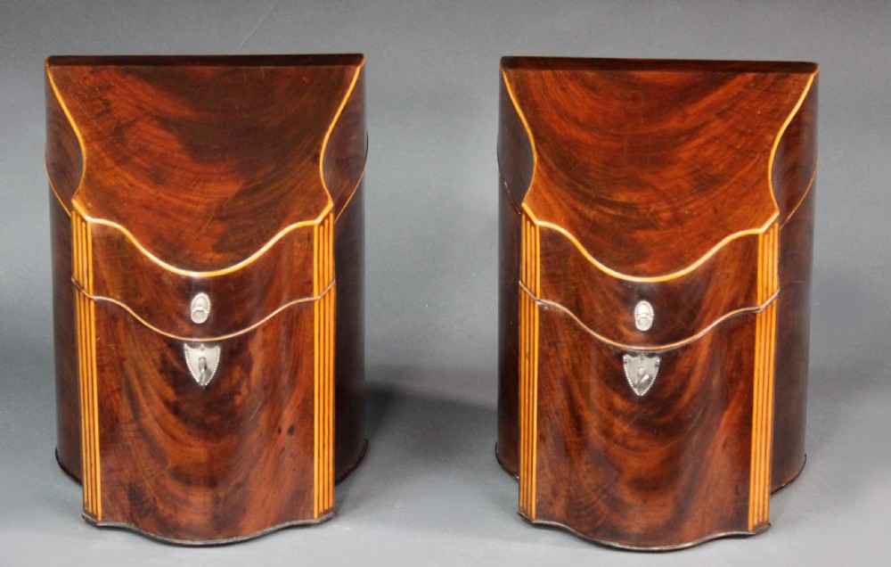 A pair of open Georgian mahogany knife boxes featuring slanted tops, star inlay on the inner lids, and slotted interior cutlery compartments. View II