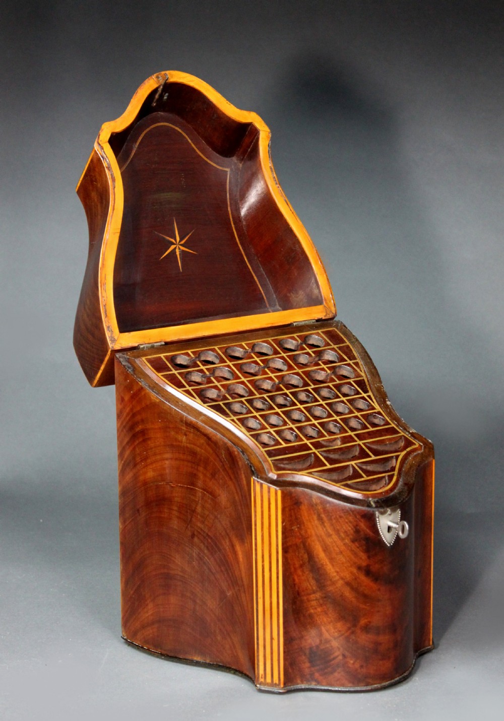 A pair of open Georgian mahogany knife boxes featuring slanted tops, star inlay on the inner lids, and slotted interior cutlery compartments. View VII