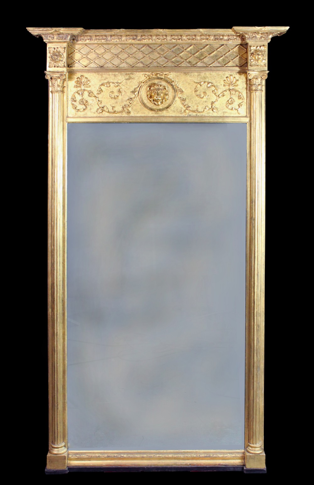 A tall Regency giltwood pier glass featuring fluted pilasters, a decorative lattice frieze, and a central lion mask motif.