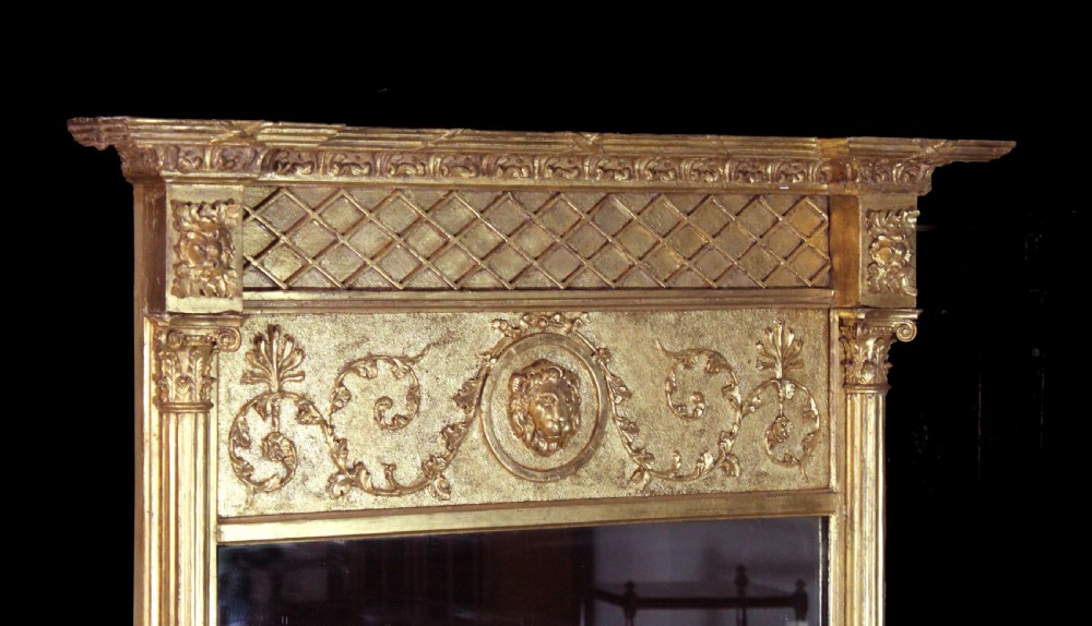 A tall Regency giltwood pier glass featuring fluted pilasters, a decorative lattice frieze, and a central lion mask motif. View III