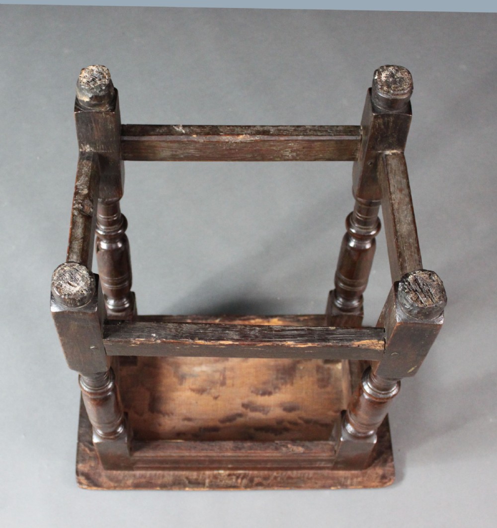 A seventeenth-century dark oak joined stool with turned legs, perimeter stretchers, and a moulded rectangular top. View III