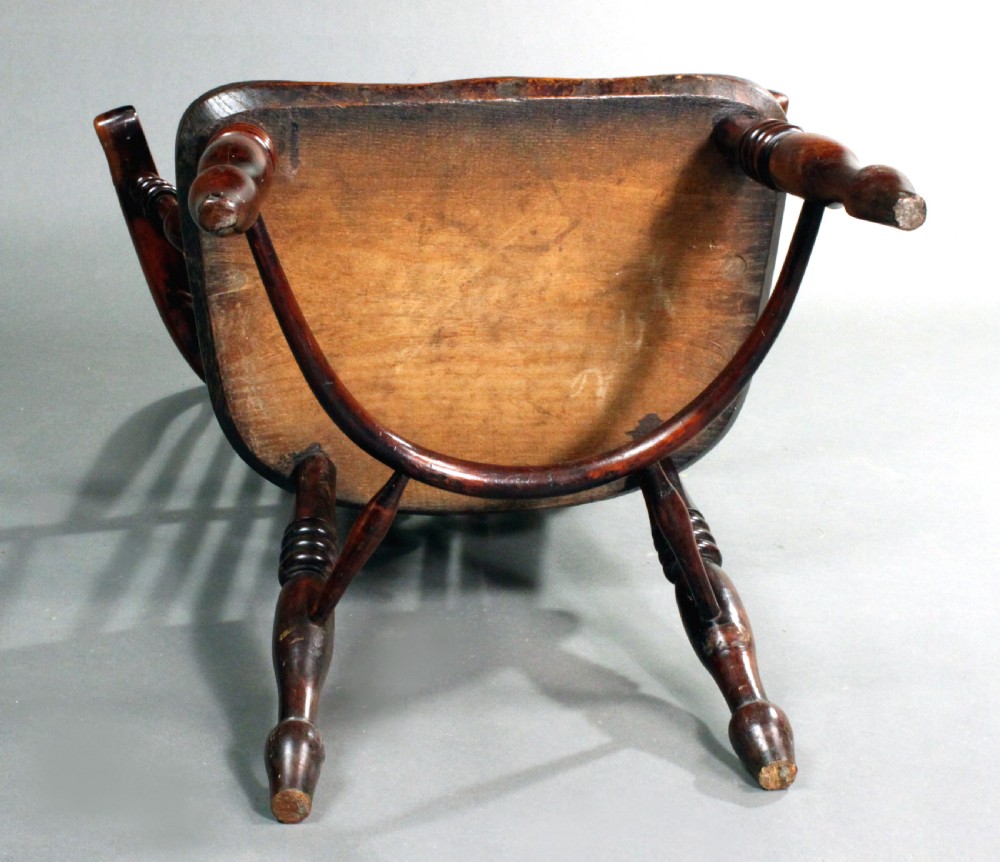 An antique yew wood Windsor armchair featuring a high bow back with vertical spindles, a pierced central splat, turned arm supports, and a shaped seat. View VII