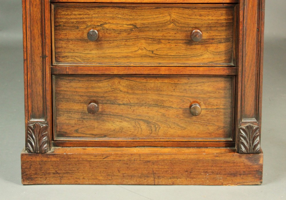A tall, narrow Victorian rosewood Wellington chest featuring seven stacked drawers with wooden knob handles and a hinged side locking bar. View VI