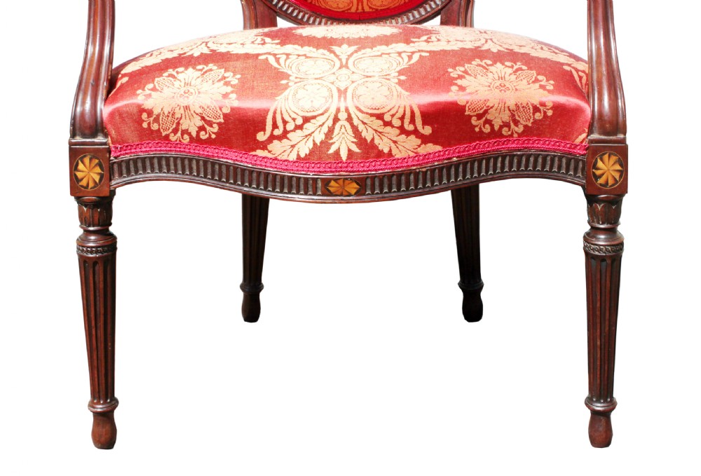 A pair of antique George III mahogany armchairs featuring oval backs and patterned red and gold damask upholstery. View VI