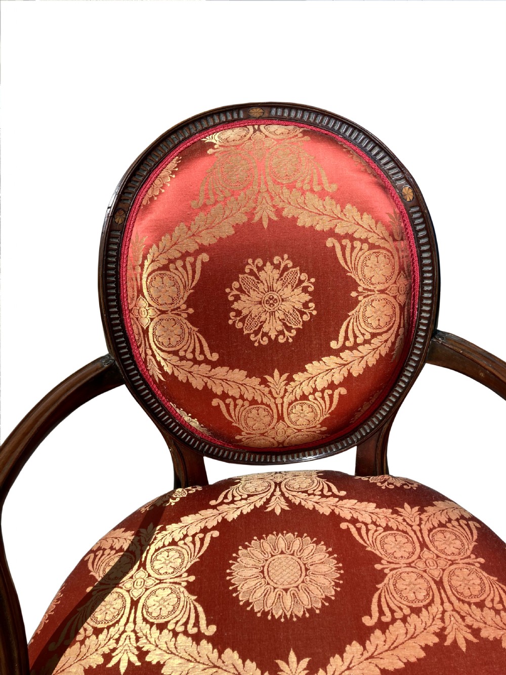 A pair of antique George III mahogany armchairs featuring oval backs and patterned red and gold damask upholstery. View VIII