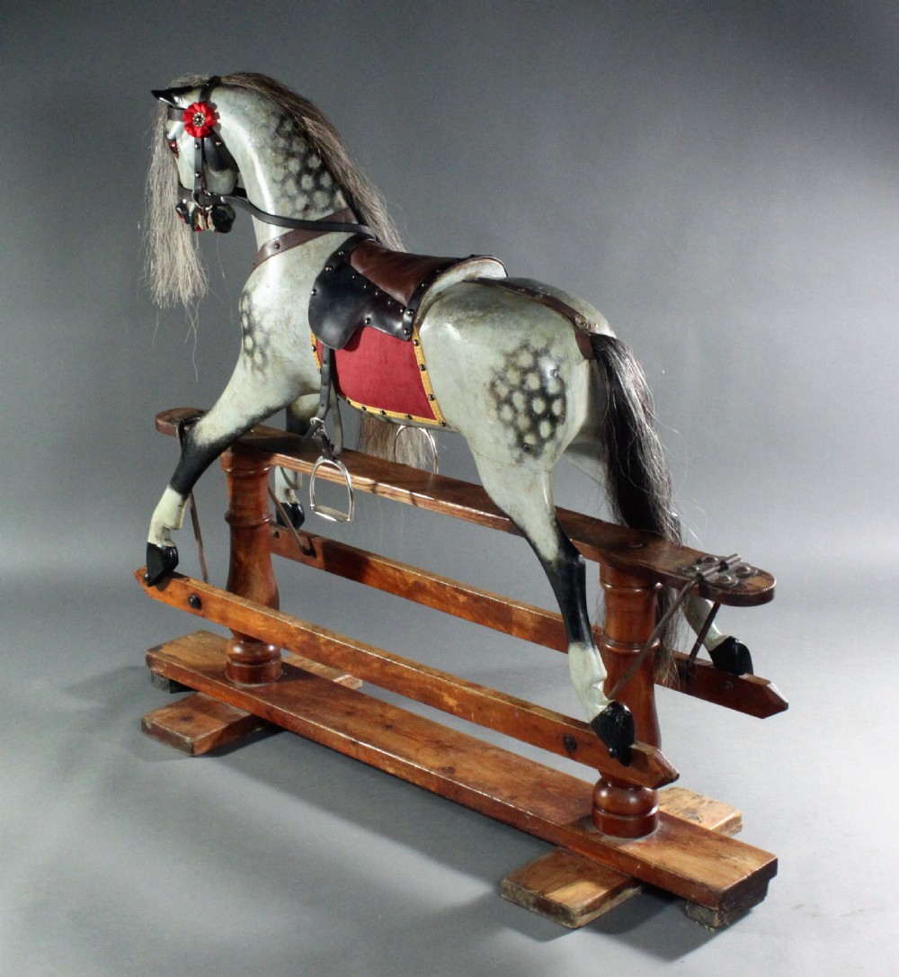 A 19th-century carved wooden dapple grey rocking horse mounted on a stained timber safety glider stand with leather tack and a natural horsehair mane. View III