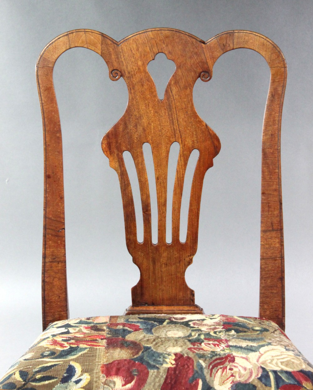 A pair of 18th-century George II walnut side chairs featuring pierced vase-shaped splats, floral upholstered drop-in seats, and front cabriole legs. View VI