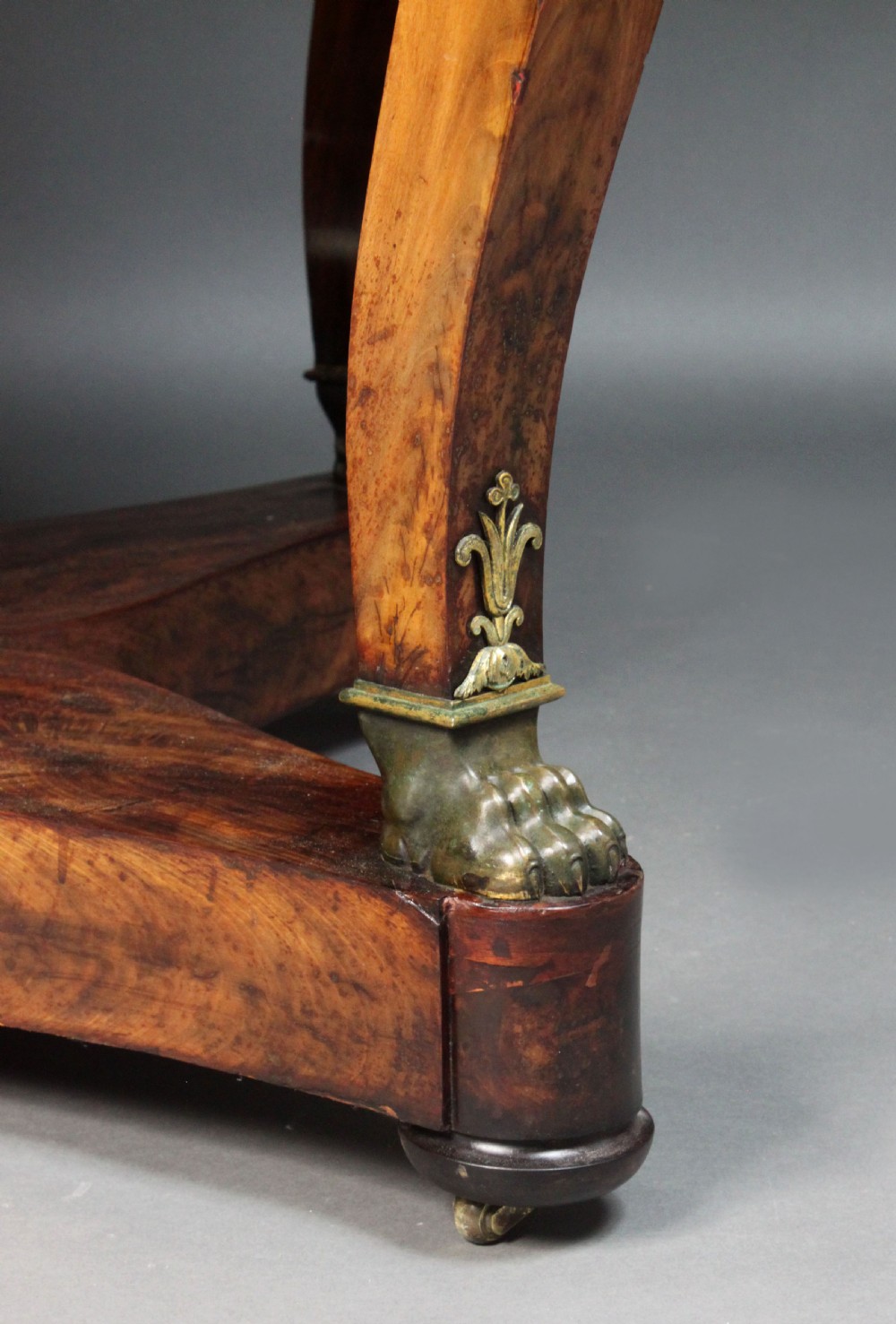 A circular French Empire centre table featuring a black veined marble top, mahogany apron with gilt bronze mounts, and curved legs on a cruciform base. View V