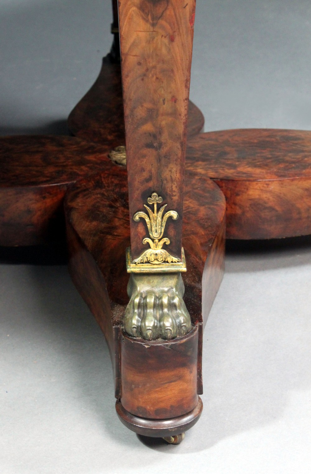 A circular French Empire centre table featuring a black veined marble top, mahogany apron with gilt bronze mounts, and curved legs on a cruciform base. View VI
