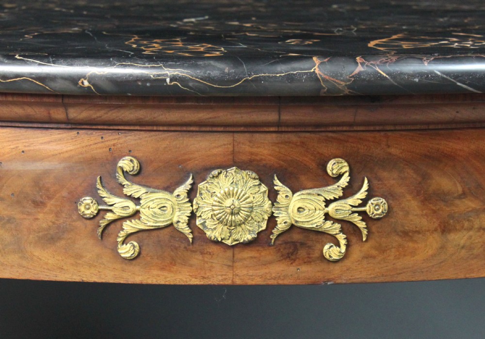 A circular French Empire centre table featuring a black veined marble top, mahogany apron with gilt bronze mounts, and curved legs on a cruciform base. View XIII