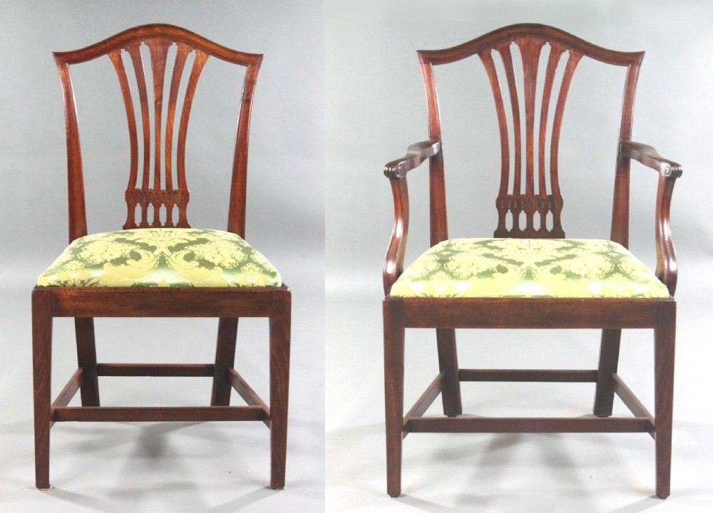 A set of eight Georgian mahogany dining chairs featuring carved pierced back splats and green damask upholstered seats, including six side chairs and two armchairs. View IV