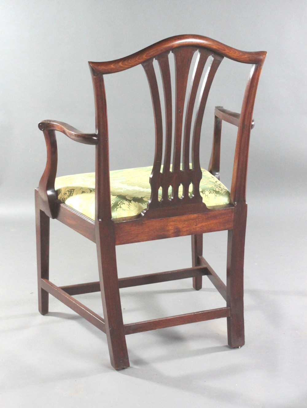 A set of eight Georgian mahogany dining chairs featuring carved pierced back splats and green damask upholstered seats, including six side chairs and two armchairs. View V