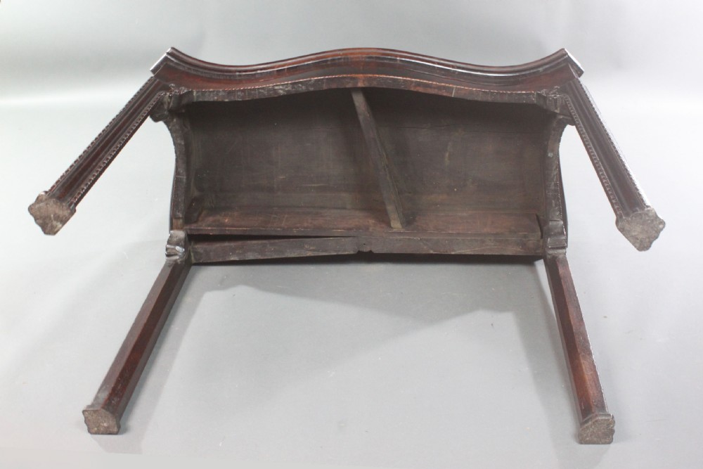 An 18th-century Chippendale style mahogany card table featuring a serpentine fold-over top, carved apron edge, and square moulded legs. View IX
