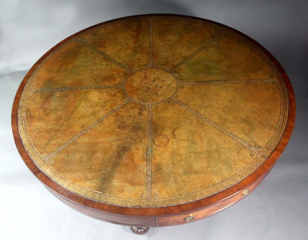 A circular Georgian mahogany drum table featuring a green leather inset top with gilt tooling, frieze drawers with brass handles, and a carved pedestal base resting on four splayed legs with castors. View VIII