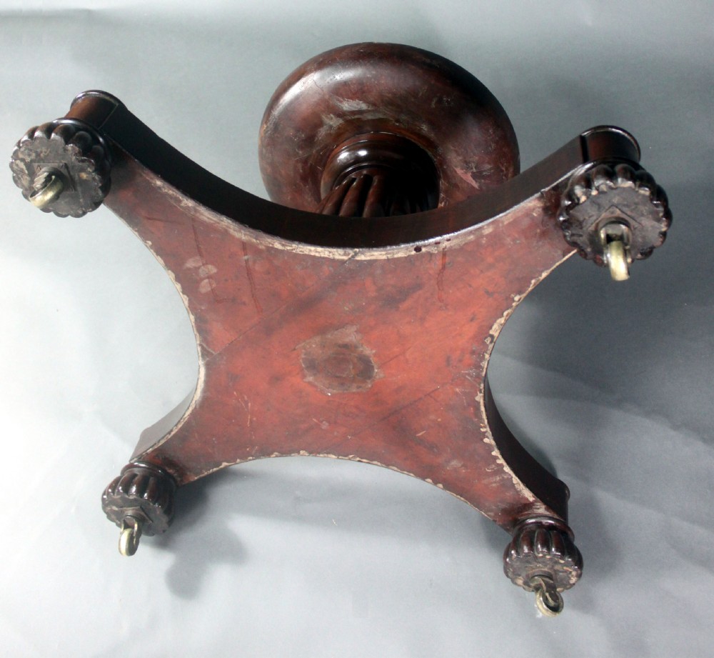A circular Georgian mahogany drum table featuring a green leather inset top with gilt tooling, frieze drawers with brass handles, and a carved pedestal base resting on four splayed legs with castors. View IX