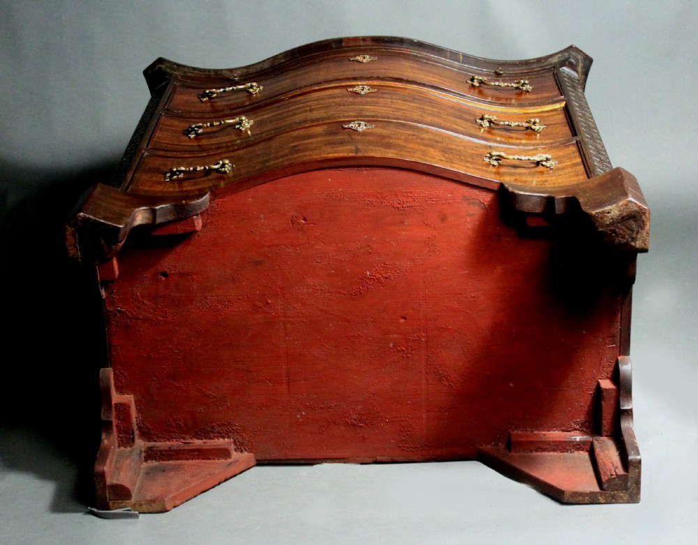 An eighteenth-century George III mahogany chest of drawers featuring a serpentine front, carved blind fretwork, brass handles, and bracket feet. View IX