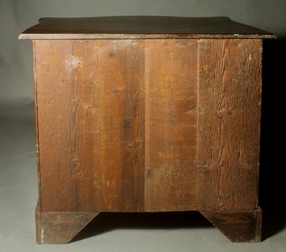 An eighteenth-century George III mahogany chest of drawers featuring a serpentine front, carved blind fretwork, brass handles, and bracket feet. View X