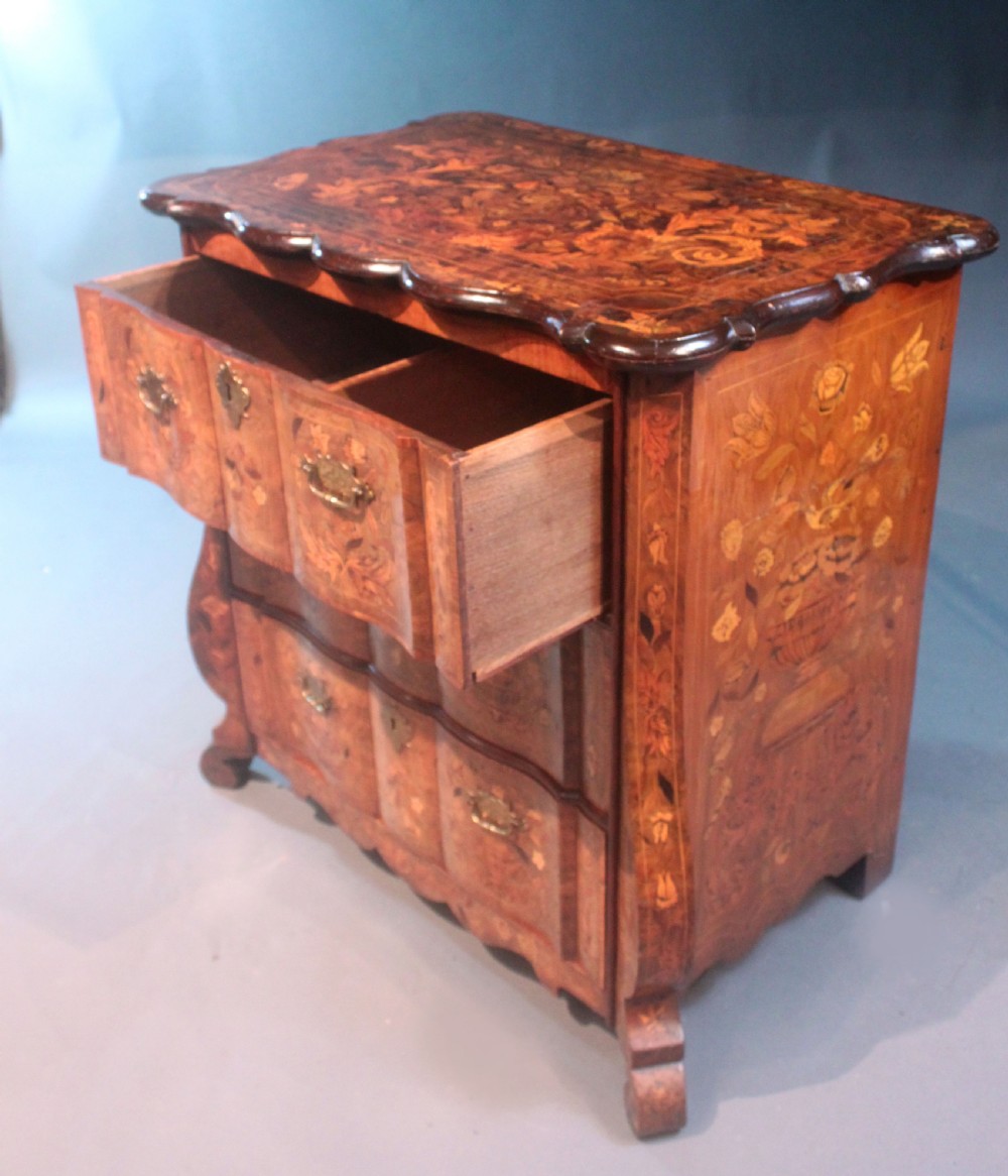 An antique Dutch marquetry chest of drawers featuring three drawers, floral wood inlay, shaped sides, and brass drop handles. View VIII