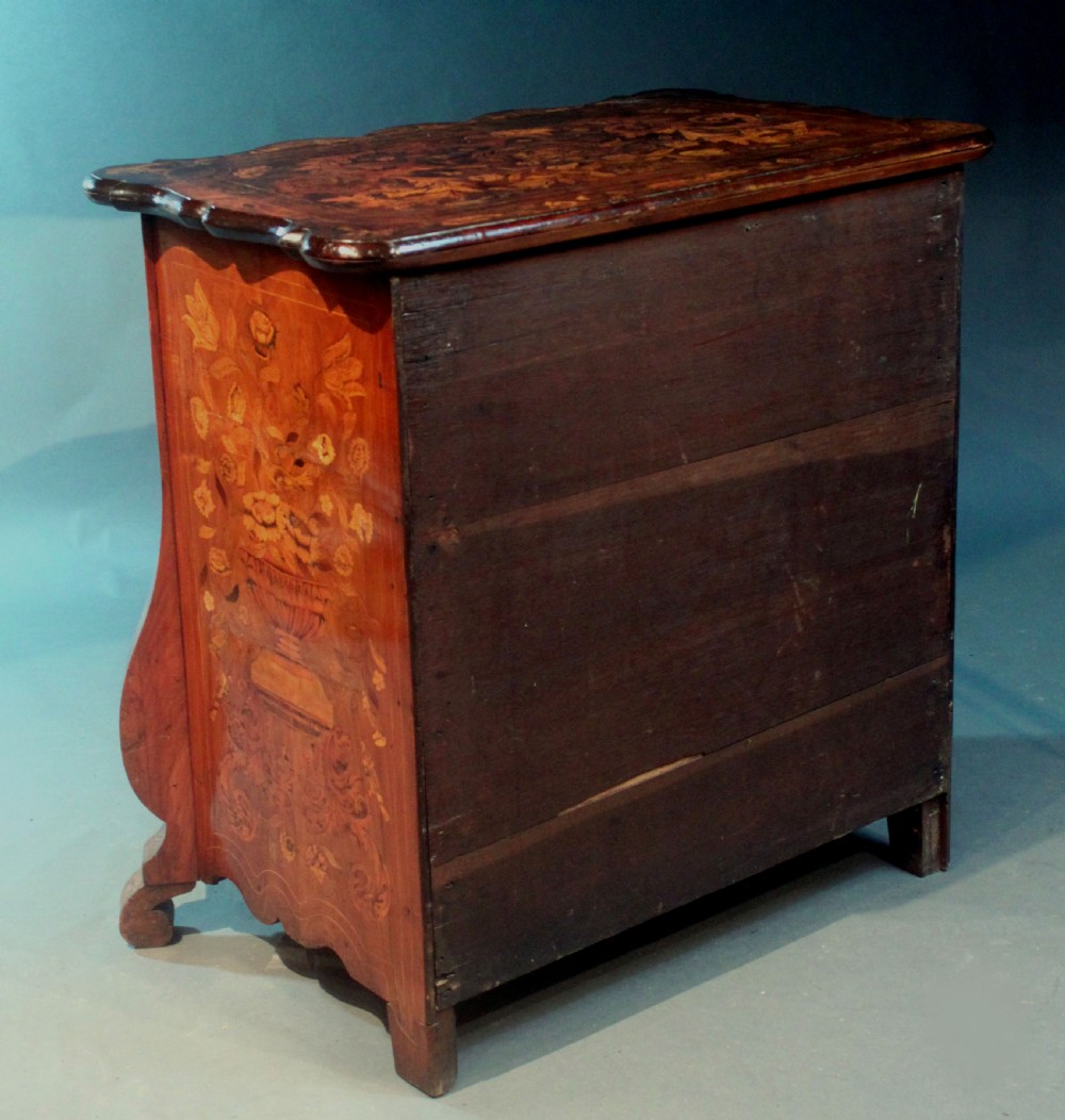 An antique Dutch marquetry chest of drawers featuring three drawers, floral wood inlay, shaped sides, and brass drop handles. View XV