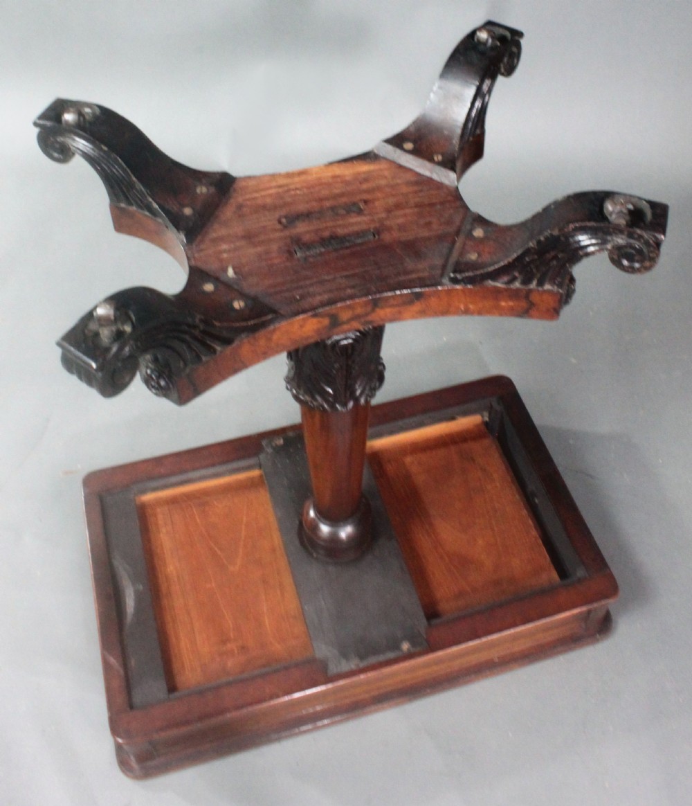 A Regency rosewood occasional table featuring a rectangular top, a tapered carved column support, and a quadform base on scroll feet. View X